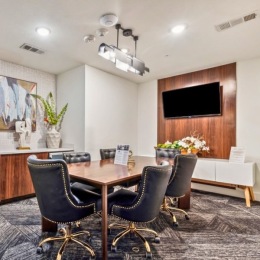 a room with a table, chairs and a tv