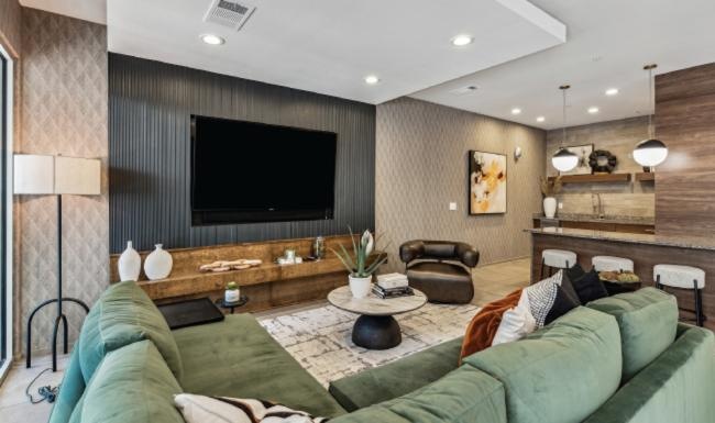 a lounge with a couch, tables, chairs and a tv